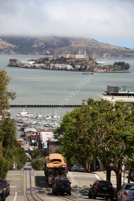 Cable car on the streets of San francisco with Alcatraz in the back ground.
