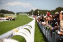 Crowd bathed in sunshine watch the 5th race.