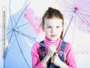 Young girl with blue eyes and umbrellas