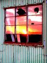 Sunset reflected in broken barn window