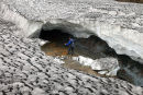 03D-5028 Trekker Looking into the Entrance of a Collapsed Ice Cave on the Laugavegur Hiking Trail from Landmannalaugar to Thorsmork Fjallabak Area of Iceland.