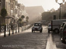 06D-8044 French Street Scene. Classic Citroen 2CV Driving Along a Street in the Pouring Rain in the Town of Ambroise Indre et Loire France