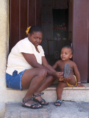 Mother fitting her child's sandals.
