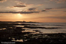 Bamburgh Castle at sunset from Seahouses Harbour