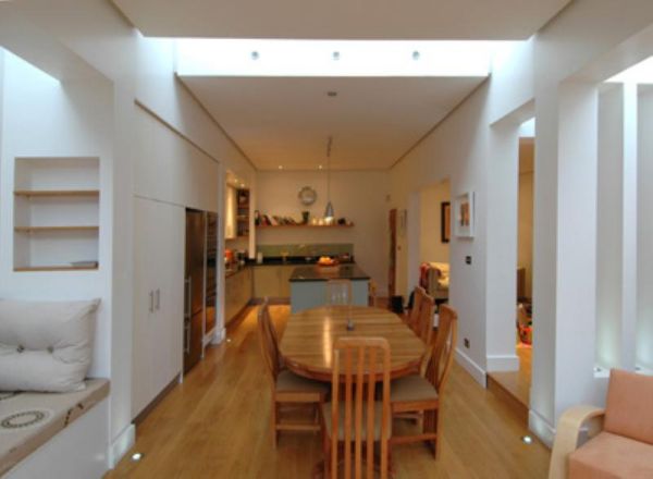 View from dining area towards kitchen. Note the ceiling edge details and integration of natural light.