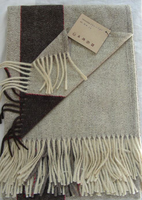 Trip blanket.
100% natural lambs wool.
1,80 x 1,30 m.
360 gr.
Colour: Ivory, Brown with a red thin line, asymmetrical design. 
Price: 80.50 
Wholesale available.